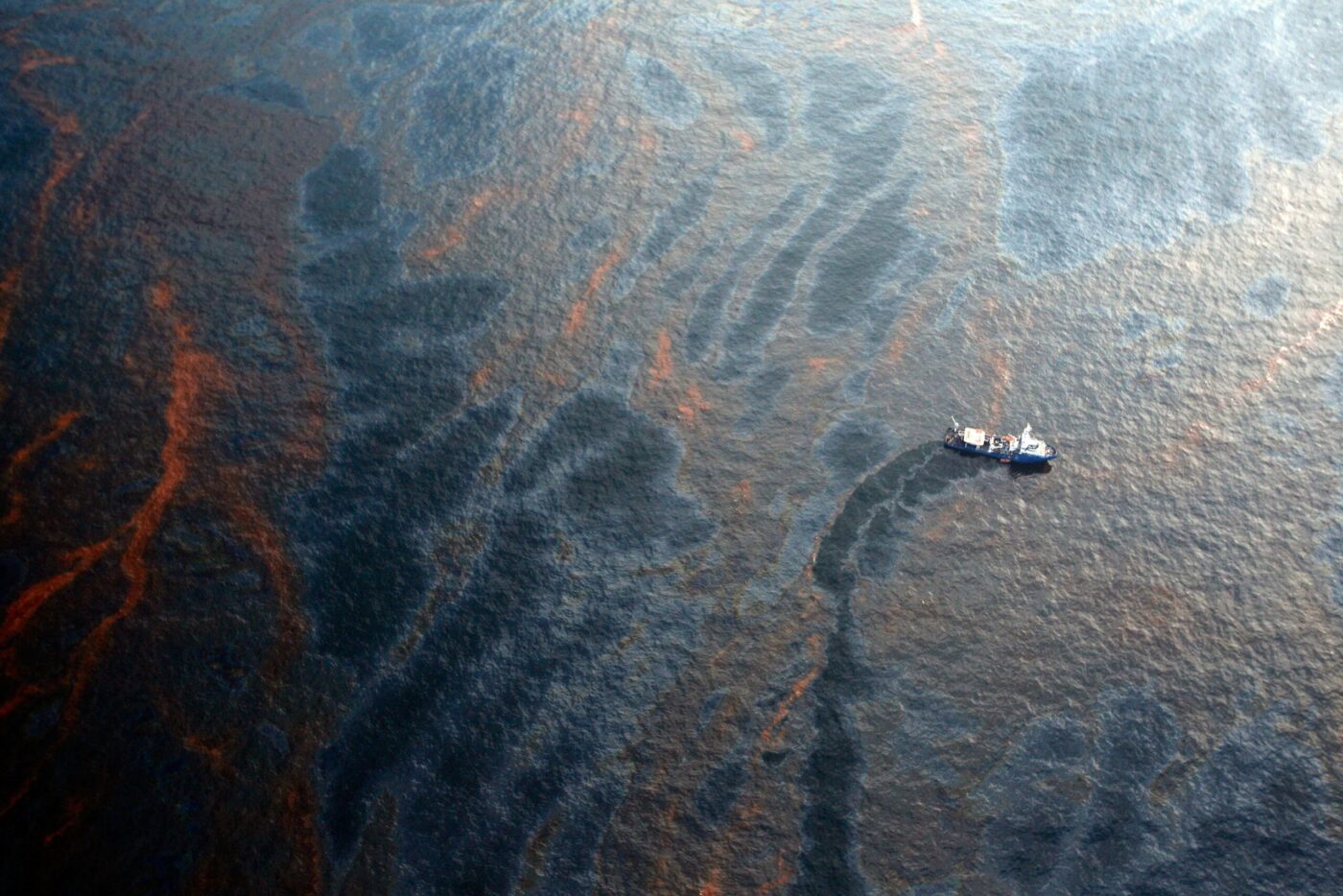 A boat works to collect oil that has leaked from the Deepwater Horizon wellhead in the Gulf of Mexico